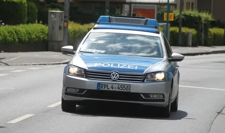 Silber-blauer Streifenwagen der Polizei fährt frontal auf einer innerörtlichen Straße
