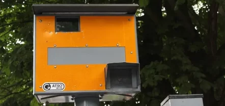 Orangefarbener Blitzerkasten mit Gatsometer-Logo an einem Mast