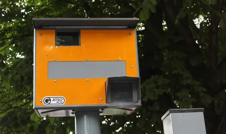 Orangefarbener Blitzerkasten mit Gatsometer-Logo an einem Mast