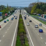Mehrspurige Schnellstraße mit fließendem Verkehr über einen längeren Streckenabschnitt