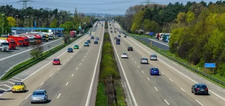 Mehrspurige Schnellstraße mit fließendem Verkehr über einen längeren Streckenabschnitt