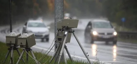 Zwei Messeinheiten auf Stativen am Rand einer Landstraße bei Regen