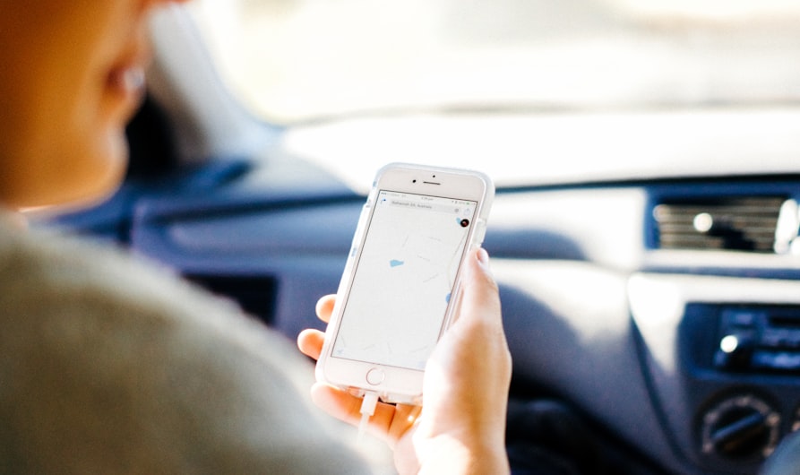 a woman holding a cell phone in a car
