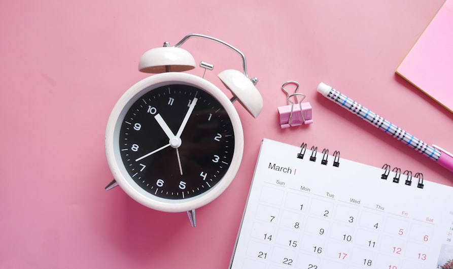 white and pink analog alarm clock